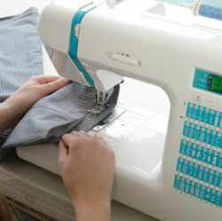 woman stitching together striped pants on sewing machine